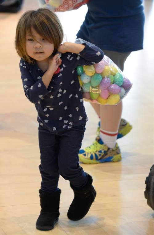 Francisco Kjolseth | The Salt Lake Tribune
Lily Dawes, 3, carries a large cache of eggs as Shriners Hospitals hosts an Easter Egg Hunt adapted for patients with physical challenges. Around 100 patients and their families attended Wednesday's annual Easter Egg Hunt, which gave children with physical challenges who may be in wheelchairs or rely on the assistance of a walker, the space, time and support they needed to enjoy the Spring time tradition.