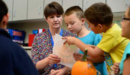 Scott Sommerdorf   |  The Salt Lake Tribune
Plymouth Elementary teacher Tara Fredley checks the work of Boston Richardson, center, and Jonathan Hernandez who were decorating pumpkins with her 2nd grade class, Thursday, October 1, 2015. Fredley is one of the most experienced teachers at the school.