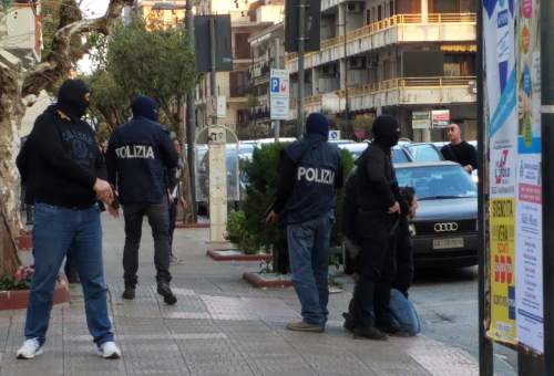 In this photo taken on Saturday, March 26,  and made available on Sunday, May 27, 2016, Italian Police arrest a man, kneeled at right, in the southern city of Bellizzi, near Salerno, Italy. Police identified the man detained as Djamal Eddine Ouali, an Algerian wanted in Belgium for facilitating illegal migration linked to the recent terror attacks in Paris. According to police he was sought under a European arrest warrant for alleged involvement in a network in Brussels which makes false documents, including those used by extremists implicated in the Paris and Brussels attacks. (Carmine Cappetti/www.asalerno.it via AP Photo) MANDATORY CREDIT