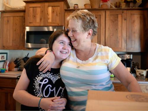 Al Hartmann  |  The Salt Lake Tribune 
Deb Scott hugs her granddaughter Hailey Whipple, 12, while working on a science project in her kitchen in West Jordan on Thursday, March 24.  Scott had hepatitis C but is now cured of the virus. Her private insurance refused to cover treatment, but she was able to get into a clinical trial through Intermountain Medical Center and is now healthy and happy and planning her future.