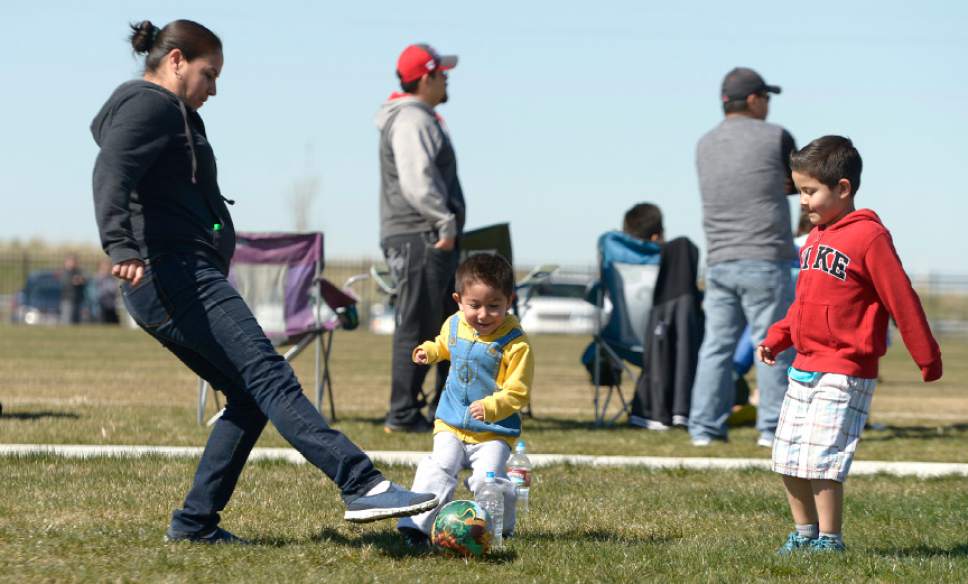 Leah Hogsten  |  The Salt Lake Tribune
l-r While at her oldest son's soccer game, Minerva Contreras keeps her youngest son, Alan Aguilar,5, (right) and his friend Alan Lopez, 3, (center) entertained with their own pick-up game. Thousands attended Salt Lake City's Regional Athletic Complex opening Saturday, April 2, 2016. Activities  included rugby, soccer, lacrosse, ultimate Frisbee and quidditch exhibition games, soccer and ultimate Frisbee clinics and Utah Bubble Balls sports activities.
