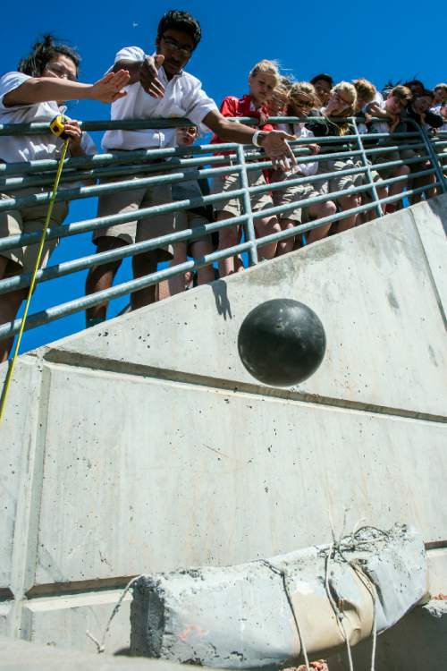 Chris Detrick  |  The Salt Lake Tribune
Chanakya Duggineni drops a bowling ball onto a concrete beam during an experiment at Judge Memorial High School Tuesday April 5, 2016. Dr. Dasch Houdeshel's students were testing the structural strength of concrete beams built with and without tin cans inside of them by dropping a 10 pound bowling ball from different heights onto them. The concrete beams without cans survived a 10 lb bowling ball dropped from 8 feet, where the beams with cans broke in half from a drop of as low as six inches.