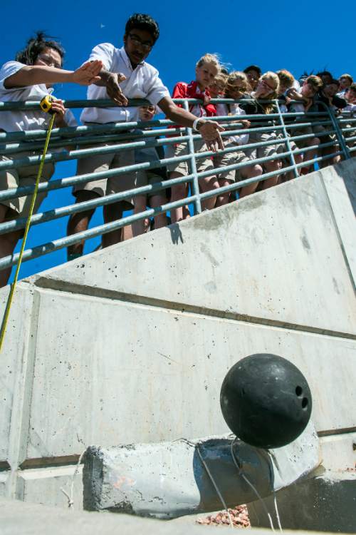 Chris Detrick  |  The Salt Lake Tribune
Chanakya Duggineni drops a bowling ball onto a concrete beam during an experiment at Judge Memorial High School Tuesday April 5, 2016. Dr. Dasch Houdeshel's students were testing the structural strength of concrete beams built with and without tin cans inside of them by dropping a 10 pound bowling ball from different heights onto them. The concrete beams without cans survived a 10 lb bowling ball dropped from 8 feet, where the beams with cans broke in half from a drop of as low as six inches.