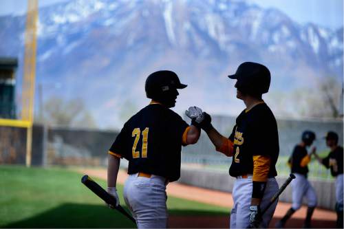 Scott Sommerdorf   |  The Salt Lake Tribune  
Kearns players Aaron Bass, left, and Graden Luckhart celebrate another run scored against Judge at Kearns, Friday, April 8, 2016. Kearns routed the Bulldogs 12-2.
