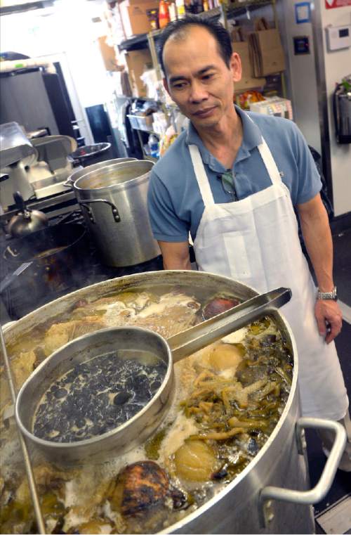 Al Hartmann  |  The Salt Lake Tribune
Chef-owner Michael Eng checks a huge batch of 24-hour, slow-boiling SOMIi Noodle Soup.