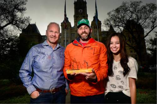 Scott Sommerdorf   |  The Salt Lake Tribune  
Dan Murray, left, and his daughter Taylor, flank SLC Marathon race director Steve Bingham-Hawk with an award dedicated to their wife and mother Marie Murray, who passed away in January after a battle with cancer, Wednesday, April 13, 2016. The "Miles for Marie" award will be presented Saturday, April 15 ahead of the 2016 Salt Lake City Marathon.
