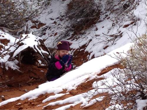 Erin Alberty  |  The Salt Lake Tribune

A young hiker snacks on newly-fallen snow on the Broken Arch Loop hike in Arches National Park.