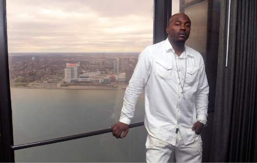 In a photo from March 28, 2016, Robert Wilcoxson stands at his hotel window in Detroit, with a view of the city of Windsor, Ontario behind him. Wilcoxson is one of two people freed by the North Carolina Innocence Inquiry Commission, and he received $5 million in compensation. (AP Photo/Jose Juarez)
