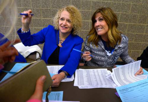 Leah Hogsten  |  The Salt Lake Tribune
l-r  Salt Lake City Mayor Jackie Biskupski and Ashley Hoopes help voters to the ballot box.  Lines and wait times were long at the Democratic caucus at Clayton Middle School as both registered party members and unaffiliated voters cast their ballots, Tuesday, March 22, 2016.