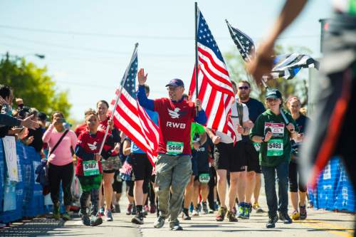 Chris Detrick  |  The Salt Lake Tribune
Members of "Team Red, White and Blue," including Jack Barney, 14, cross the finish line during the Salt Lake City marathon and half marathon Saturday April 16, 2016.
