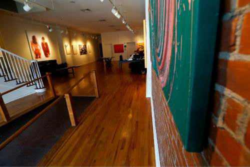 Artwork, left, by painter Tom Dash, depicting a partially a nude woman, hangs at Borghi Fine Art Gallery in Englewood, N.J., Tuesday, April 19, 2016. The gallery has filed a federal lawsuit arguing that its constitutional rights were violated when it was fined $1,250 per day and the owner, Laura Borghi, was threatened with up to 90 days in jail over the artwork, which shows a woman's bare buttocks. A city code says nude images have to be kept in interior rooms not visible from public areas. (AP Photo/Julio Cortez)