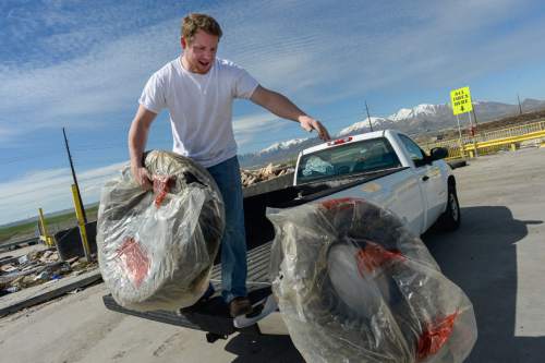 Francisco Kjolseth | The Salt Lake Tribune 
John Eagan of Salt Lake unloads a set of tires for disposal at the landfill. Salt Lake County Council is considering raising fees for tires and refrigerators to be disposed of at the landfill, to cover the recycling costs.