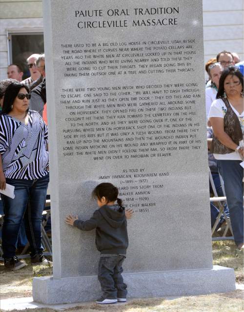Al Hartmann  |  The Salt Lake Tribune
Two-year-old Krysin Pikyavit touches monument during dedication as Paiute Tribal members, Circleville residents, Utah Division of State History, and LDS Church History representatives gather at the town park Friday April 22 for a new memorial recognizing the men, women and children of the Koosharem Band of the Paiute Indian Tribe killed during the Circleville Massacre in late April 1866.
