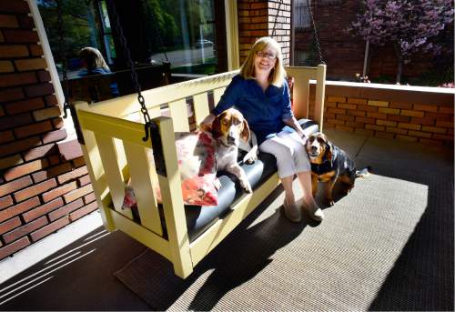 Scott Sommerdorf   |  The Salt Lake Tribune  
Lana Schowengerdt and the family dogs sit on the porch swing of the prairie-style home she owns with her husband John on Wednesday, April 20, 2016.  The Utah Heritage Foundation 45th Annual Homes Tour takes place  Saturday, April 30, in the tree-lined University neighborhood. Six historic homes, including this one, will be open to the public.