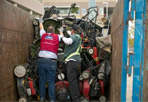 Lennie Mahler  |  The Salt Lake Tribune

Jon Gordon and Ed Larrat load old trade-in gas lawnmowers into a dumpster as Lowe's and the DEQ offered new, environmentally friendly gas-powered lawnmowers and trimmers at a discount during their CARROT program, Saturday, April 23, 2016.