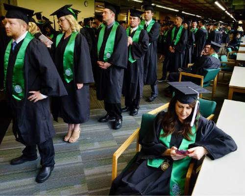 Trent Nelson  |  The Salt Lake Tribune
Utah Valley University graduate Wendy Ellison checks her phone while waiting for Commencement to begin in Orem, Thursday April 28, 2016. UVU awarded 5,409 degrees at its historic 75th Commencement.