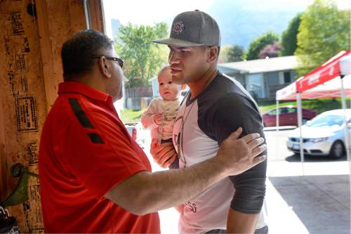 Scott Sommerdorf   |  The Salt Lake Tribune  
Utah DE Jason Fanaika, right, greets his father Sefita as he arrives at the NFL draft party with his daughter Loumaile. Fanaika, his wife Brittney and his daughter waited for his  name to be called during the NFL draft at the house of his father, Sefita Fanaika, Saturday, April 30, 2016.