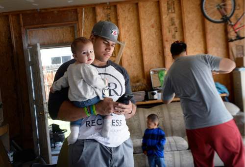 Scott Sommerdorf   |  The Salt Lake Tribune  
Utah DE Jason Fanaika holds his daughter Loumaile as he keeps in touch with his agent and the progress of the NFL draft while waiting for his name to be called during the NFL draft at the house of his father, Sefita Fanaika, Saturday, April 30, 2016.