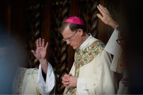 Scott Sommerdorf   |  The Salt Lake Tribune
Hands are raised over Archbishop John Wester as prayers for him are said during his final Mass at the Cathedral of the Madeleine, Sunday, May 31, 2015. Wester has been bishop of the Salt Lake City diocese and its 300,000 Catholics since March 2007, and is to be installed as archbishop of the Sante Fe diocese on Thursday (June 4).