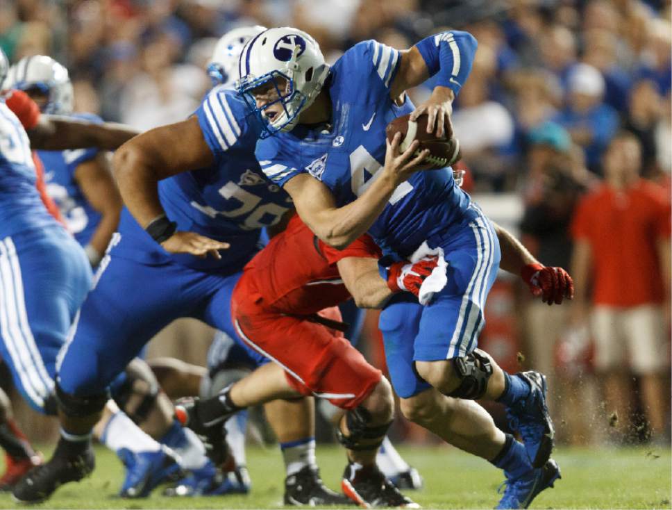 Trent Nelson  |  The Salt Lake Tribune
Brigham Young Cougars quarterback Taysom Hill (4) slips out of Utah Utes defensive end Trevor Reilly's hands in the second quarter as the BYU Cougars host the Utah Utes, college football Saturday, September 21, 2013 at LaVell Edwards Stadium in Provo.