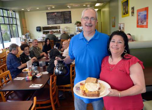 Al Hartmann  |  The Salt Lake Tribune
MariAnn Jessee and husband Mike with her father's famous breakfast -- the "Roundhouse" -- at the new Landmark Grill at 760 Fort Union Blvd. in Midvale.