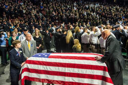 Chris Detrick  |  The Salt Lake Tribune
Law Enforcement and members of the pubic salute as Officer Douglas Scott Barney's flag-draped casket is brought into the Maverik Center Monday January 25, 2016. Barney was shot Jan. 17 in a confrontation with Cory Lee Henderson, a fugitive parolee who was fleeing the scene of a traffic accident in Holladay. Henderson later was killed in a shootout with officers, according to police.
