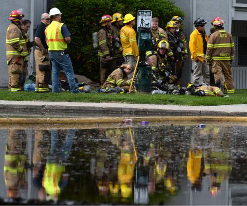 Steve Griffin / The Salt Lake Tribune

Fire fighters keep an eye on hot spots of a large apartment fire near 500 east and 4100 south in Salt Lake CityThursday May 5, 2016. They are reflected in water that filled the parking lot as a result of their fire fighting efforts.