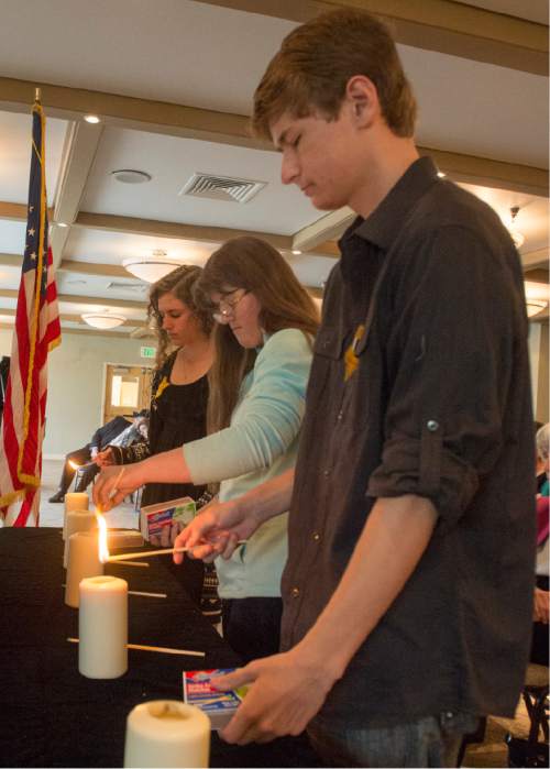 Rick Egan  |  The Salt Lake Tribune

L-R Manon Maurer, Erica Jorgensen, and Tyler Israd, light the memorial candles at the Utah Holocaust Memorial Commemoration at the Jewish Community Center, Thursday, May 5, 2016.