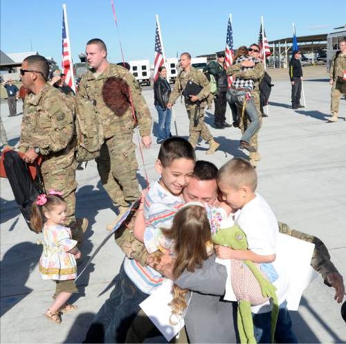 Al Hartmann  |  The Salt Lake Tribune
Master Sgt. Christopher Aguilar of Hill Air Force Base's 421st F-16 fighter squadron has his arms full with his children arriving home Tuesday, May 10 after an eight month assignment in Afghanistan.