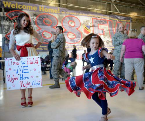 Al Hartmann  |  The Salt Lake Tribune
Lisa Bradbury watches her daughter Raegan, 6, twirl in the dresses they made especially for her husband Master Sgt. Scott Bradbury's return  May 10, 2016, at Hill Air Force base. Maintenance and support personnel for Hill Air Force Base's 421st Fighter Squadron arrived home after an eight-month assignment in Afghanistan.