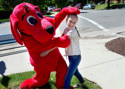 Scott Sommerdorf   |  The Salt Lake Tribune  
Lilli Durham, 10, is getting her head playfully scratched by a life-sized "Clifford The Big Red Dog" at the Scholastic "Summer Reading Road Trip" pop-up book festival at the King's English Bookshop, Wednesday, May 11, 2016.