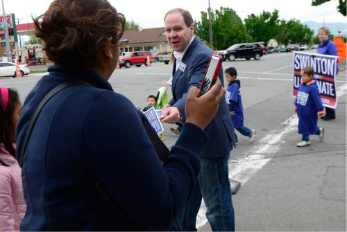 Scott Sommerdorf   |  The Salt Lake Tribune  
Jonathan Swinton, a Democratic Senate candidate hands out a campaign card as he walks in the Midvale Cinco de Mayo parade, Saturday, May 7, 2016. Swinton and Misty Snow are the Democratic candidates facing off in the June primary.