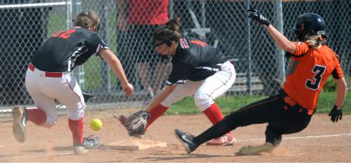 Steve Griffin / The Salt Lake Tribune

Uintah third baseman Jaden Lance and shortstop Hailey Johnson scramble after the ball as Murray's Preslee Jensen slides safely into third in the first round of the Class 4A softball tournament in Murray Tuesday May 17, 2016.