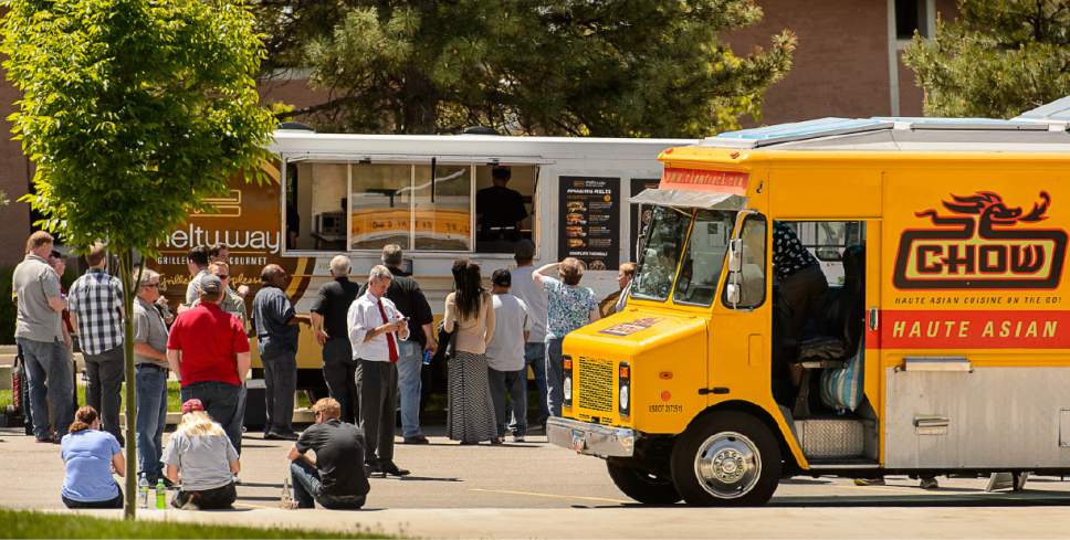 Trent Nelson  |  The Salt Lake Tribune
 Salt Lake County is contemplating expanding its business licensing ordinance to allow food trucks, such as these serving meals Friday in front of the Huntsman Center in Salt Lake City, in unincorporated areas of the county.