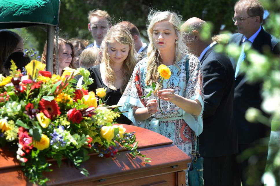 Scott Sommerdorf   |  The Salt Lake Tribune  
Sara Prawitt, granddaughter of former U.S. Senator Bob Bennett, places a rose on his casket during interment services at the Salt Lake City Cemetery, Saturday, May 14, 2016.