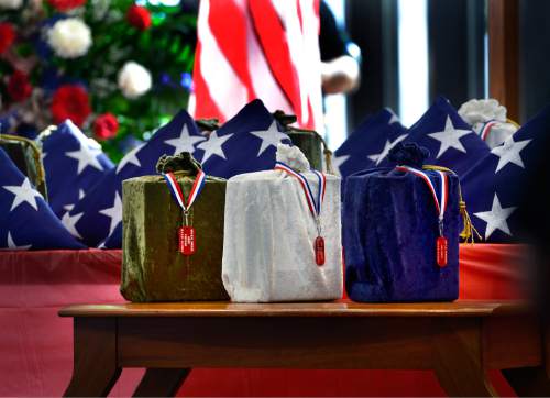 Scott Sommerdorf   |  The Salt Lake Tribune
Three containers which hold, from left to right, the remains of an Army, Navy and Air Force veteran whose remains have never been claimed. They sit among the 19 others who were interred in a service at the state veterans cemetery in Bluffdale, Saturday, August 1, 2015.
