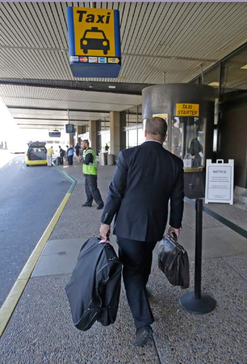 Rick Bowmer  | Tribune file photo
A traveler walks up to a taxi stand at the Salt Lake City International Airport in this 2015 file photo. After agreements were reached with ride-hailing services, such as Uber and Lyft, those companies have taken 25 percent of the market in recent months.