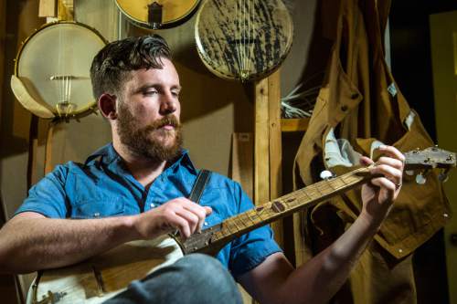 Chris Detrick  |  The Salt Lake Tribune
Craftsman Thomas Larsen poses for a portrait with custom banjos he has built in his basement workshop in American Fork Thursday May 12, 2016. Larsen started Blackberry Banjo Co. in 2009 and says about making banjos, "My favorite part is the hands-on experience. I get to take pieces of wood and turn it into something that sounds good and makes somebody happy. It brings me joy to make it and then it makes me happy when other people are playing them."