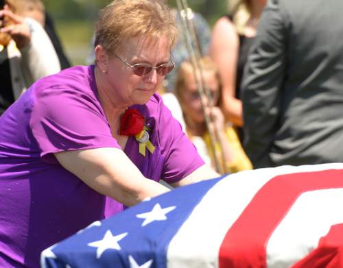 Leah Hogsten  |  The Salt Lake Tribune
Lorie Ricks lingers for a moment at the casket of her husband, Utah Transit Authority electrician Kay Ricks, 63, who was laid to rest on Saturday at Lehi City Cemetery. Ricks served in the Navy and was a veteran of the Vietnam War, 4 years active duty and 2 years in the Naval Reserve and 8 years in the Utah National Guard. Utah police continue gathering evidence that could link two men who fled to Wyoming, after tying up and assaulting a mother and her four teenage daughters in a Centerville home on May 10, to the slaying of Ricks employee whose body was found in rural Wyoming.