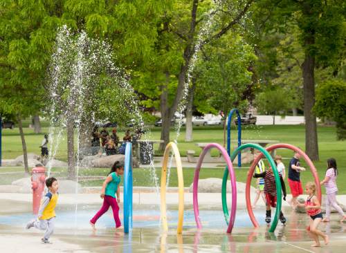 Rick Egan  |  The Salt Lake Tribune
Kids play in the water features in the Rotary Play Park at Liberty Park on Friday.