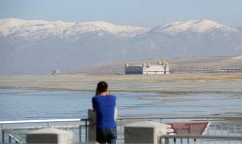 Al Hartmann  |  The Salt Lake Tribune
Signs of the Great Salt Lake's low water level is evident at the Great Salt Lake Marina State Park Thursday Feb 25.  Visitor looks across the sand to Salt Air concert venue sitting high and dry.  Hard to believe the building was surrounded by water and nearly lost in the mid 1980's when the lake's water level was at a modern day high.  The lake has been steadily falling since 2012.