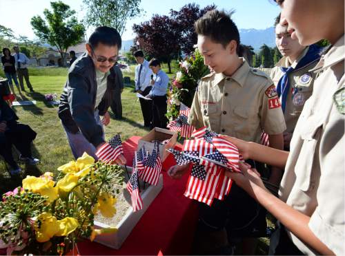 Scott Sommerdorf   |  The Salt Lake Tribune  
Byron Watanabe places a flag in remembrance of his uncle, Russell T. Fujino, during a memorial service Sunday, May 29, 2016, honoring the achievements and sacrifices of Japanese American men killed in action fighting for the United States in World War II and other Japanese American veterans who have passed on. Most of those killed and honored by the monument were members of the 100th Infantry Battalion, the 442nd Regimental Combat Team and the Military Intelligence Service (MIS), U. S. Army units that received the U. S. Congressional Gold Medal of honor in 2010.