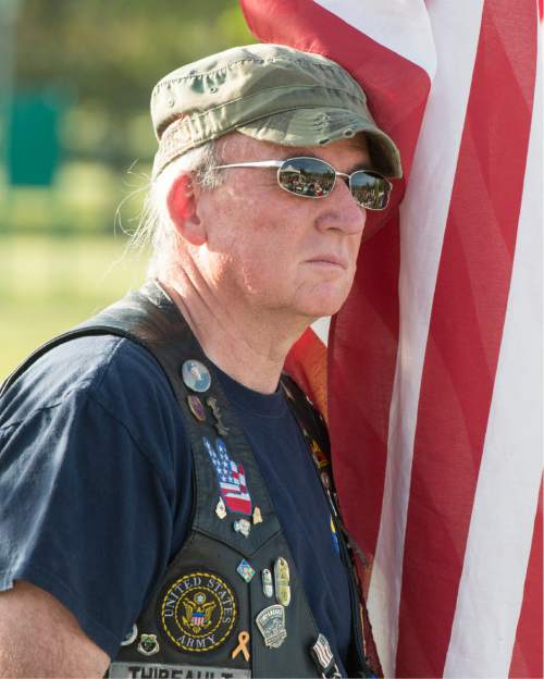 Rick Egan  |  The Salt Lake Tribune

Gold Star Father, John Thibeault, father of Jordan Thibeault, who was killed in Iraq in 2008, holds a flag as he stands with the Patriot Guard Riders, at the West Jordan Memorial Day service at Veterans Memorial Park, Monday, May 30, 2016.