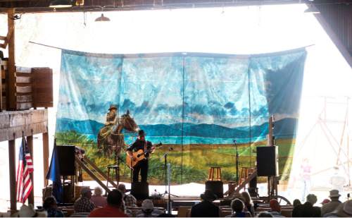 Steve Griffin / The Salt Lake Tribune

A painted back drop hangs from the barn as Stan Barnhart sings at the Annual Cowboy Poetry and Music Gathering at the Fielding Garr Ranch on Antelope Island Monday May 30, 2016. The celebration of the West featured  music, poetry, wagon rides, childrenís activities, food.