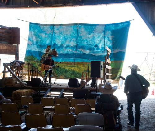 Steve Griffin / The Salt Lake Tribune

A painted back drop hangs from the barn as Stan Barnhart sings at the Annual Cowboy Poetry and Music Gathering
 at the Fielding Garr Ranch on Antelope Island Monday May 30, 2016. The celebration of the West featured  music, poetry, wagon rides, children's activities, food.