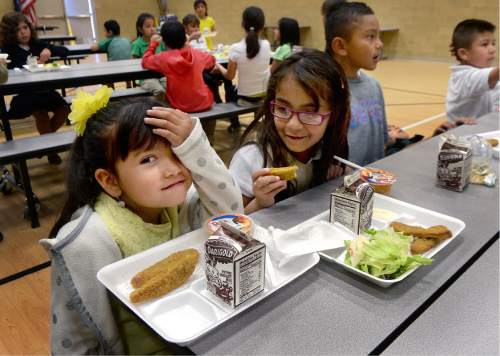 Scott Sommerdorf   |  The Salt Lake Tribune  
First grader Abby Peña, left, sits with her lunch of chicken fingers, salad and a fruit cup at Esperanza Elementary on Wednesday, June 1, 2016. A federally sponsored summertime lunch program is growing in Utah, targeting Beehive State students who qualify for free and reduced-price lunches during the school year.