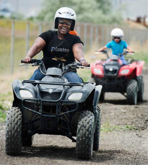 Rick Egan  |  The Salt Lake Tribune

Nakia Armstrong, Salt Lake, leads 8-year-old Skyler Salazar, as she she takes a spin on an ATV for the first time in her life, during Outdoor Adventure Days at the Lee Kay Public Shooting Range in Salt Lake City on Friday, June 10, 2016. The free event continues Saturday with fishing, kayaking and paddleboarding, and archery and firearms instruction.