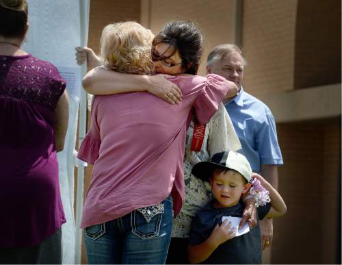 Scott Sommerdorf   |  The Salt Lake Tribune  
Wendy Black, widow of Dale Black, who lost his life in the Crandall Canyon mining rescue attempt, foreground, is hugged after having read his name during a ceremony for the new Miners Memorial in Castle Dale on Saturday. Many family members came up one by one to read off the names of those lost in Utah's mining disasters.