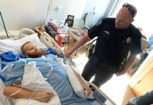 Francisco Kjolseth | The Salt Lake Tribune
Officer Kent Cameron, whose son used to play sports with Brady Holt at Riverton High School, checks in on the USU defensive lineman who was badly injured in a May car crash. Currently recovering at Intermountain Medical Center in Murray, Brady sustained severe brain injuries that have mostly left him in a vegetative state, although small signs of recognition are starting to emerge, giving the family hope.