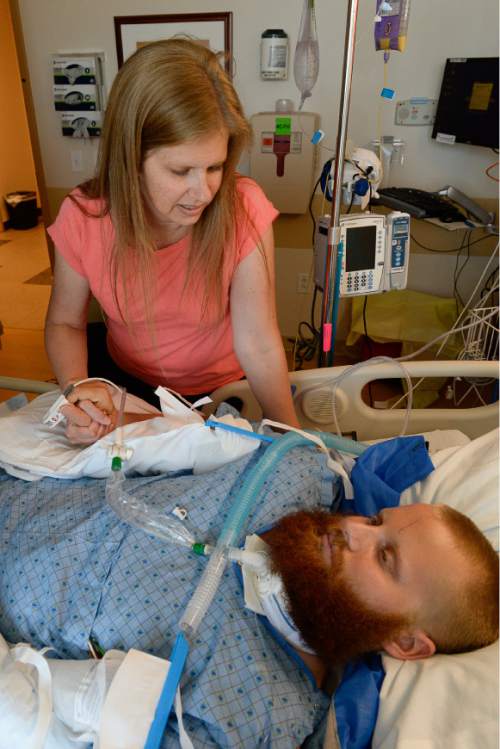 Francisco Kjolseth | The Salt Lake Tribune
Christy Holt tries to get a reaction from her son Brady as he begins a slow recovery at Intermountain Medical Center in Murray. Brady, a 6-foot-6 USU defensive lineman known to have a gentle and kind heart, was badly injured in a May car crash.